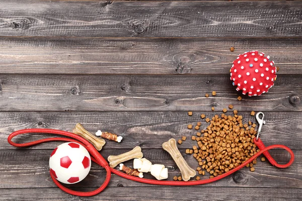 Droog huisdier voedsel met kraag en speelgoed ballen op houten tafel — Stockfoto