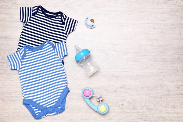 Bayi pakaian dengan mainan, soother dan botol di lantai — Stok Foto