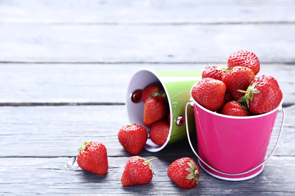 Frische Erdbeeren in Eimern auf grauem Holztisch — Stockfoto