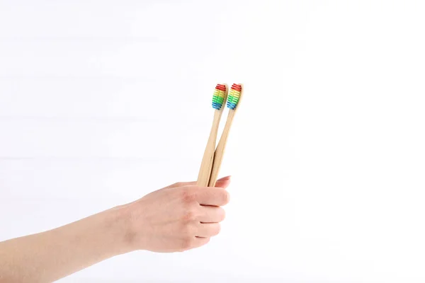 Bamboe tandenborstels in vrouwelijke hand op witte achtergrond — Stockfoto