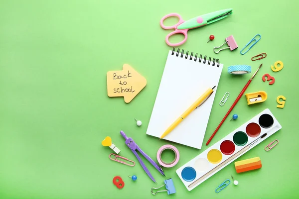 Iscrizione Ritorno a scuola con materiale scolastico su sfondo verde — Foto Stock