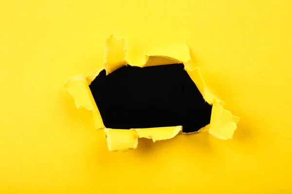 Черная дыра в желтой бумаге — стоковое фото