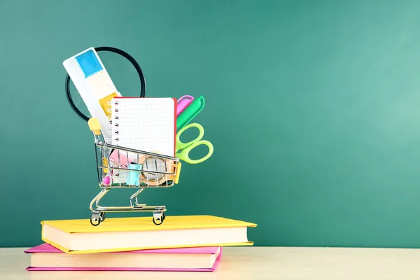 School supplies with books on chalkboard background — Stock Photo, Image