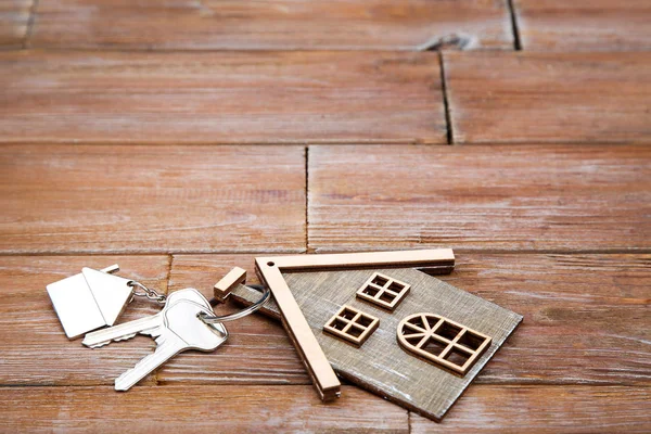 Llaves de plata con símbolo de la casa en la mesa de madera marrón — Foto de Stock