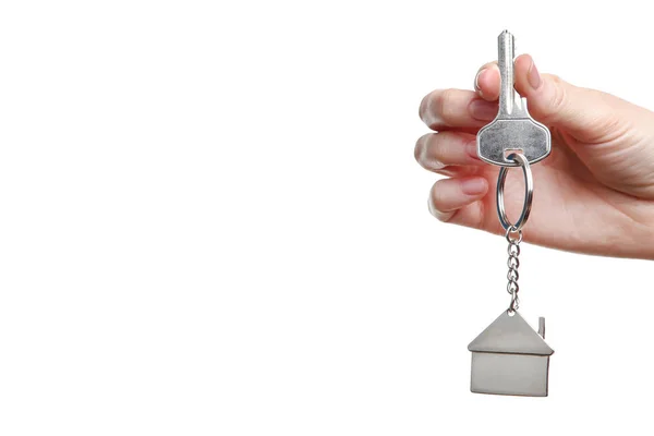 Vrouwelijke hand houden zilveren sleutel met huis symbool op witte backgr — Stockfoto
