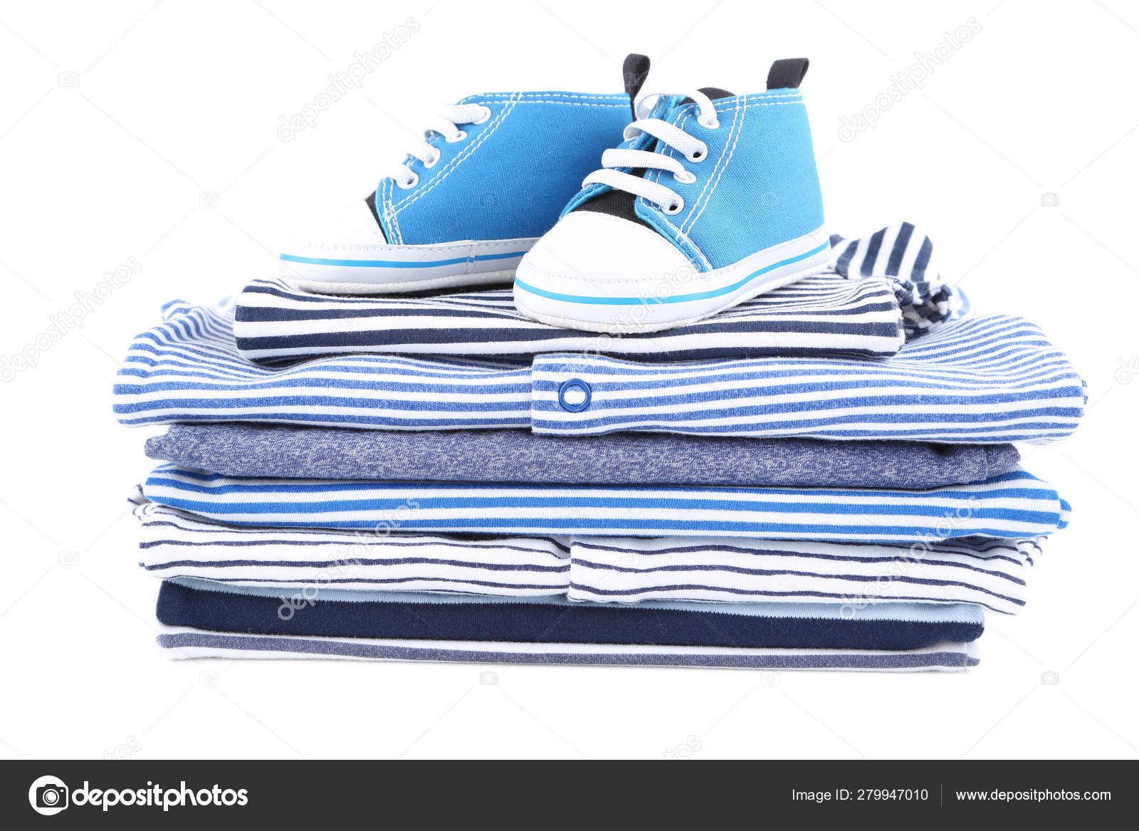 Roupas de bebê dobradas diferentes com par de sapatos isolados no