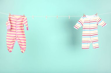 Mavi arka planda asılı bebek kıyafetleri