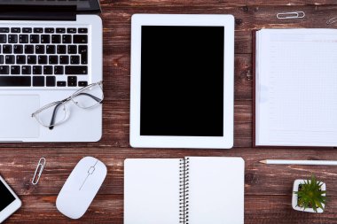 Dizüstü bilgisayar, gözlüklü tablet bilgisayar, ahşap üzerinde fare ve not defterleri