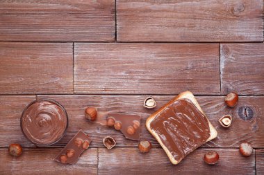 Kahverengi ahşap masada erimiş çikolata ve fındık ile ekmek