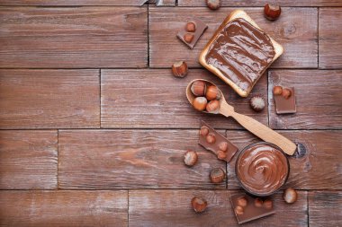 Kahverengi ahşap masada erimiş çikolata ve fındık ile ekmek