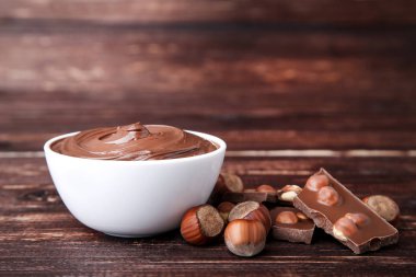 Kahverengi ahşap masada fındık ile erimiş çikolata