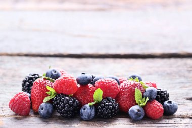 Gri ahşap masada olgun ve tatlı meyveler