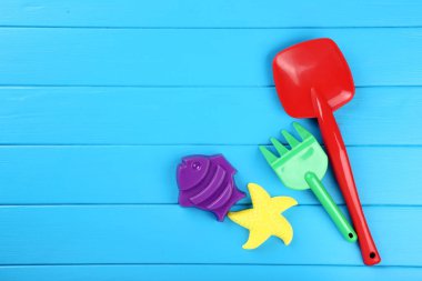 Mavi ahşap masa üzerinde plastik plaj oyuncakları