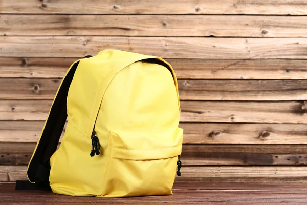 Plecak szkolny na brązowym drewnianym stole — Zdjęcie stockowe