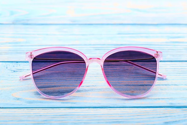 Сучасні сонцезахисні окуляри на синьому дерев'яному столі — стокове фото