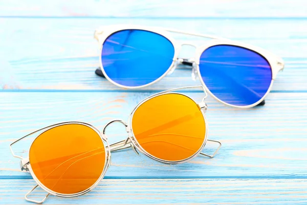 Färgglada solglasögon på träbord — Stockfoto