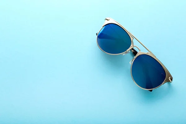 Сучасні сонцезахисні окуляри на синьому фоні — стокове фото