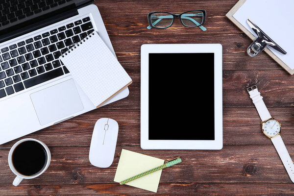 Laptop and tablet computer with mouse, glasses and cup of coffee