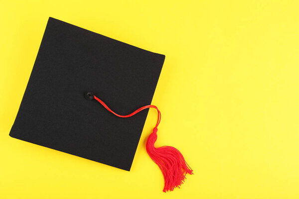 Graduation cap on yellow background