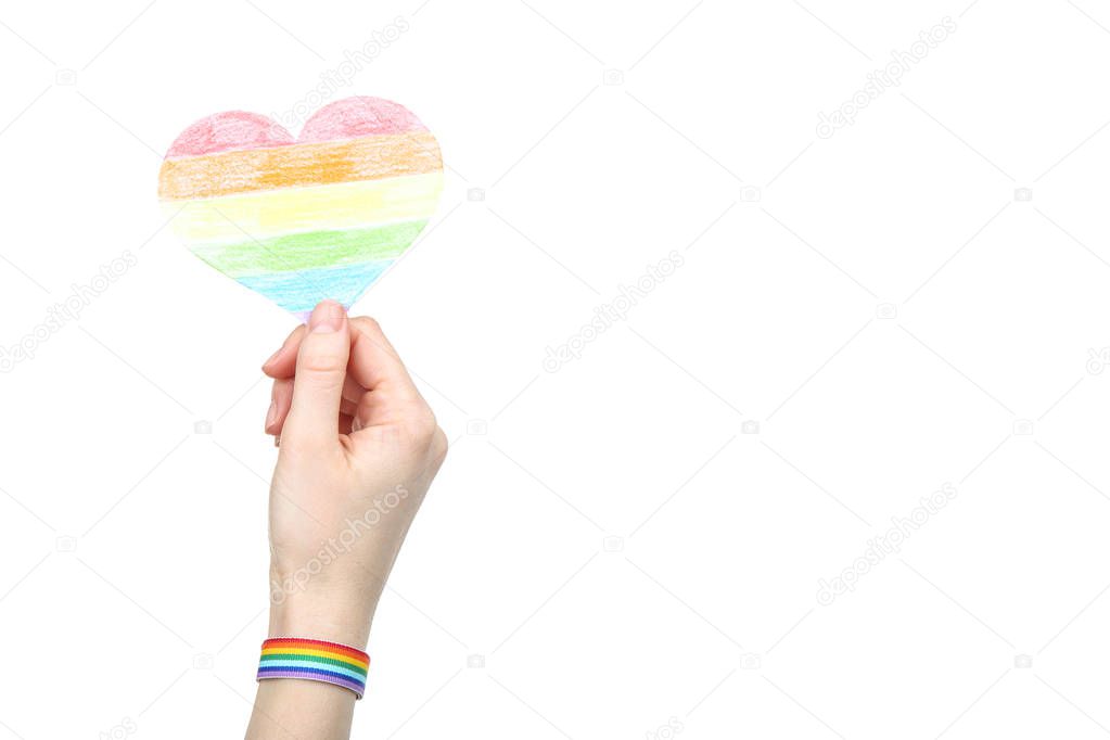 Female hand holding rainbow paper heart on white background