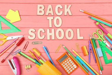 Ahşap masa üzerinde kırtasiye ile Okula Metin Geri