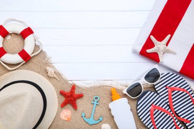 Beyaz ahşap ta üzerinde deniz kabukları ve güneş kremi ile Moda giyim