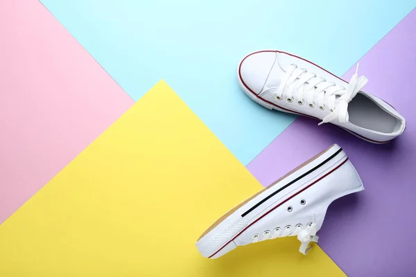 Пара білих кросівок на барвистому фоні — стокове фото