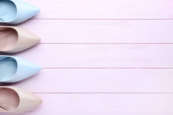 Zapatos de tacón alto diferentes en mesa de madera rosa —  Fotos de Stock