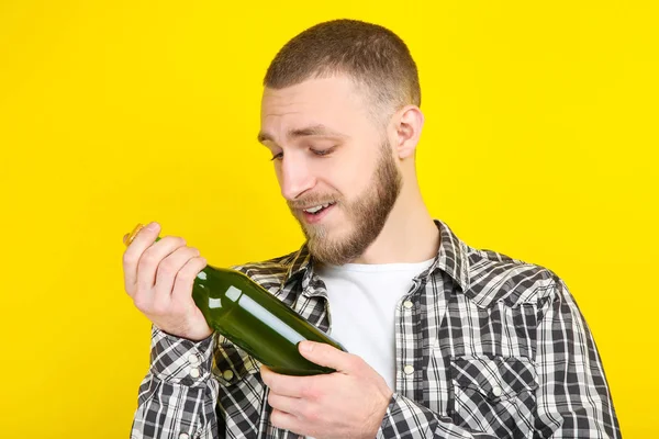 Joven con botella de cerveza sobre fondo amarillo — Foto de Stock