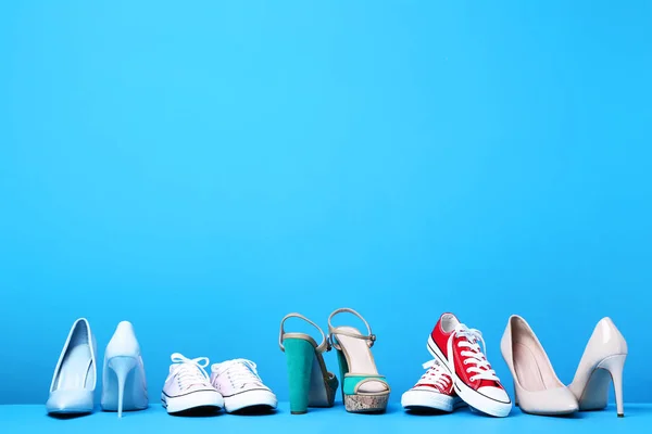 Zapatos femeninos diferentes sobre fondo azul —  Fotos de Stock