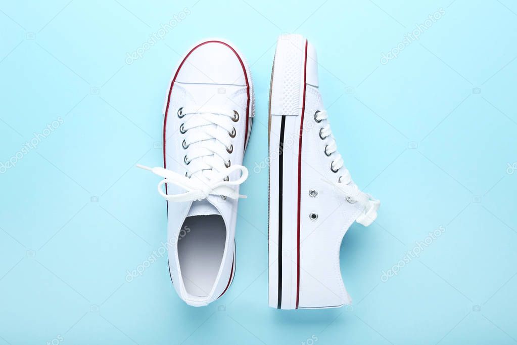 Pair of white sneakers on blue background