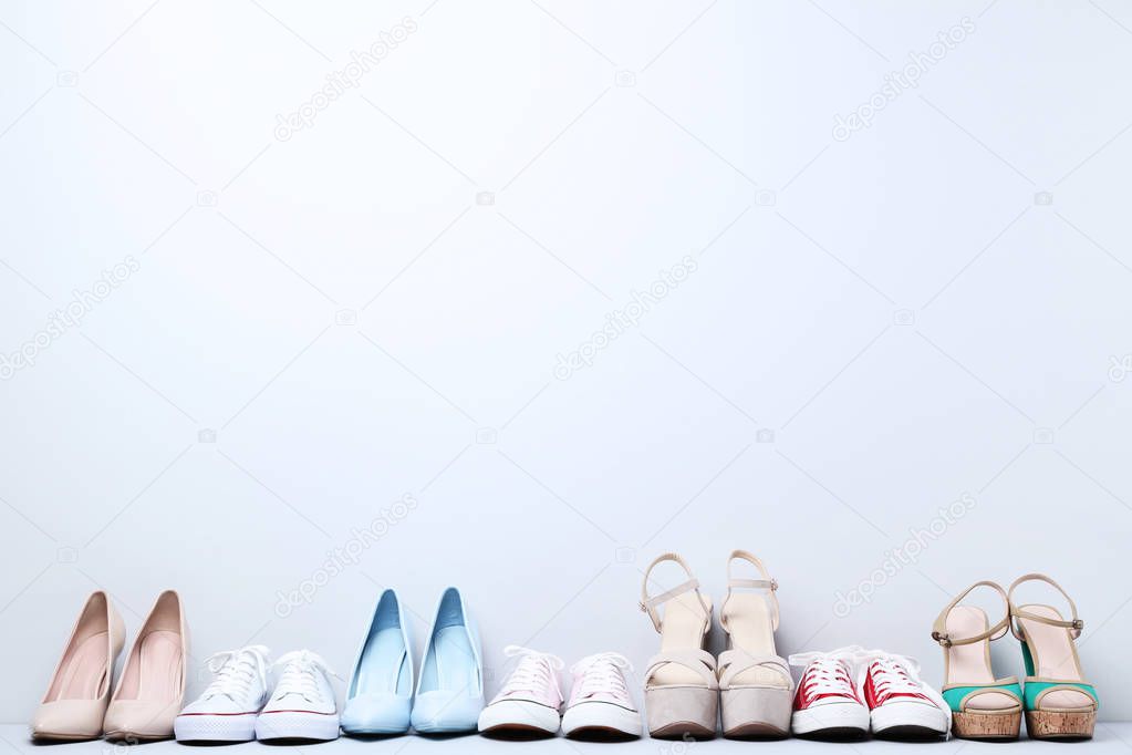 Different female shoes on grey background