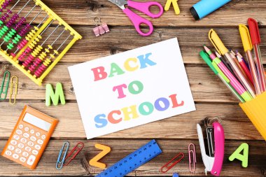 Kahverengi ahşap masa üzerinde kırtasiye ile Okula Metin Geri