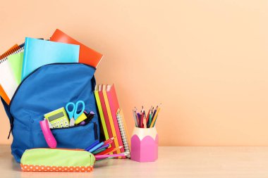 Bej arka planda okul malzemeleri ile Sırt Çantası