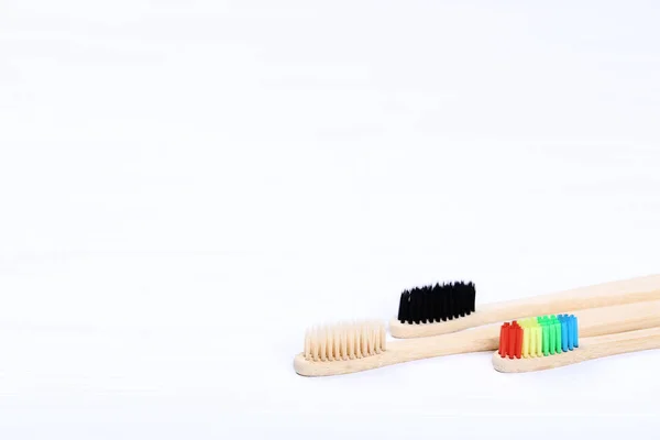 Bamboo toothbrushes on white wooden table — Stock Photo, Image