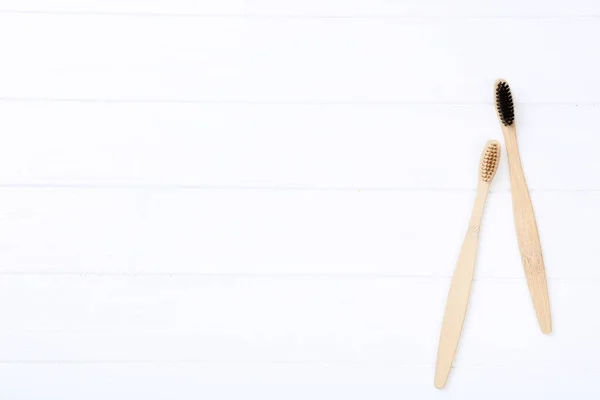 Escovas de dentes de bambu na mesa de madeira branca — Fotografia de Stock