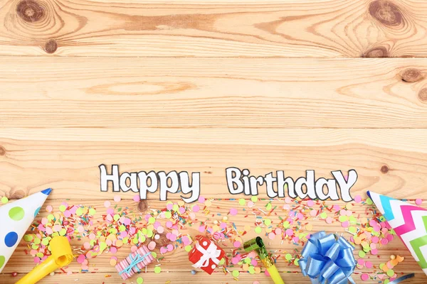 Text Happy Birthday with party decorations on wooden table — Stock Photo, Image