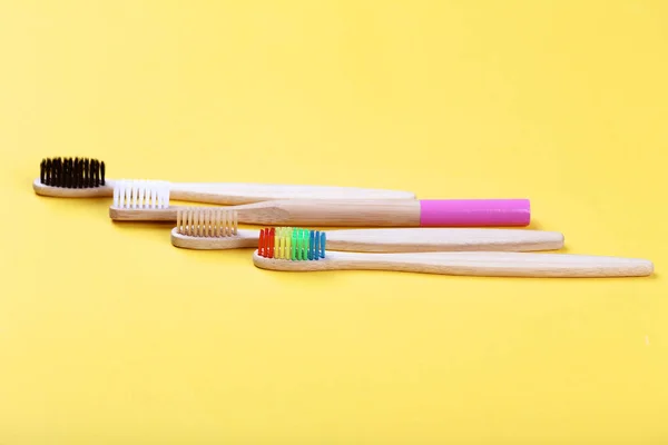 Bamboo toothbrushes on yellow background — Stock Photo, Image