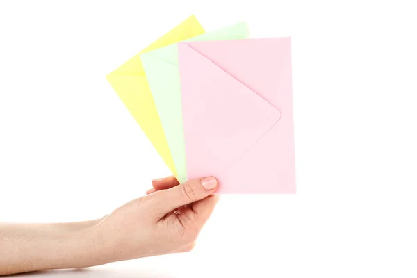 Mão feminina com envelopes de papel colorido sobre fundo branco — Fotografia de Stock