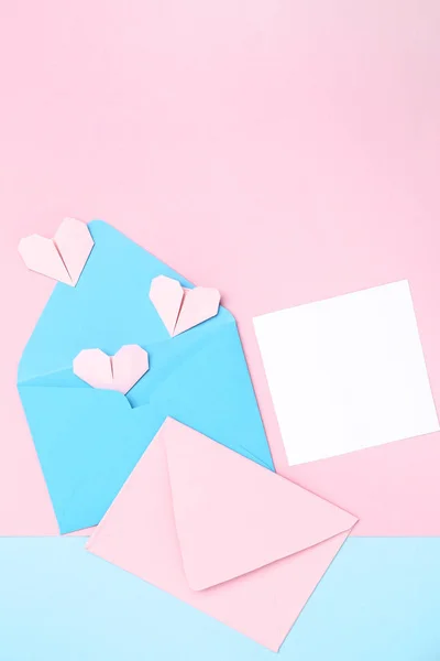 Papierumschläge mit Herzen und Blanko-Karte auf buntem Hintergrund — Stockfoto