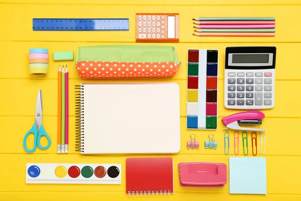 Persediaan sekolah dengan lembaran kertas kosong di atas meja kayu kuning — Stok Foto