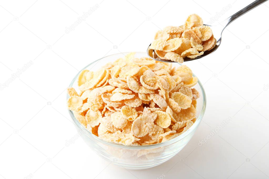 Corn flakes in bowl with spoon on white background