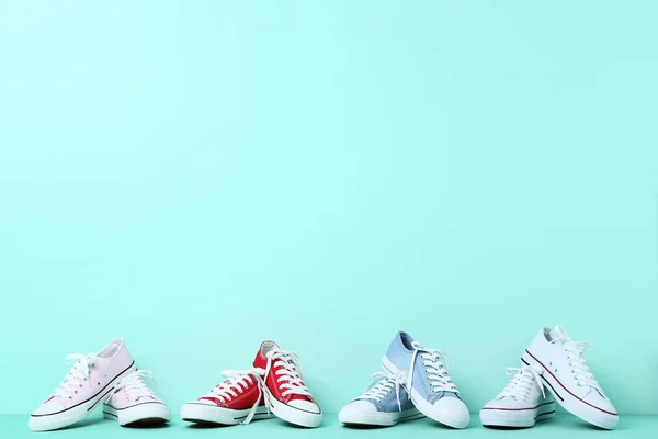 Different colorful sneakers on mint background — Stock Photo, Image