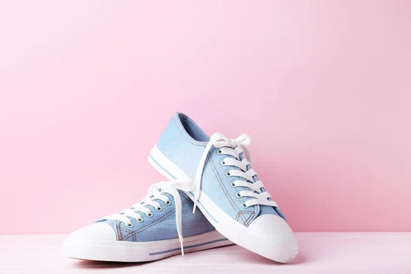 Pair of blue sneakers on pink wooden table — Stock Photo, Image