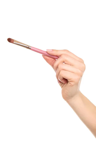 Pincel de maquiagem na mão feminina no fundo branco — Fotografia de Stock