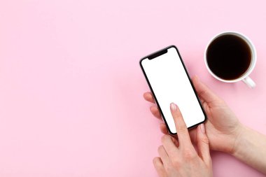 Pembe arka planda kahve fincan ile elinde Smartphone