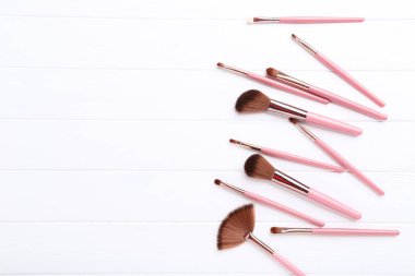 Beyaz ahşap masada makyaj fırçaları seti