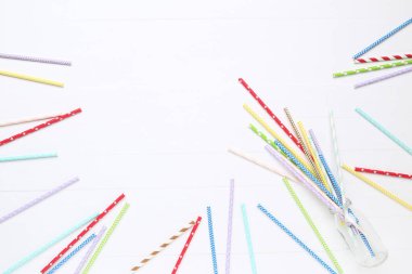 Beyaz ahşap masada renkli kağıt pipetler