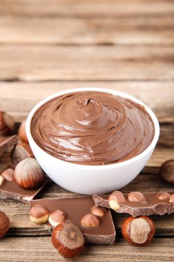 Kahverengi ahşap masada fındık ile erimiş çikolata