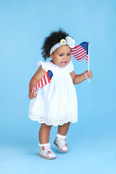 Красива дівчинка з американськими прапорами на синьому фоні — стокове фото
